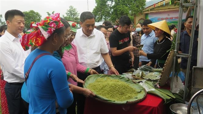 Provincial leaders and residents visit exhibition booths featuring Hop Thanh green sticky rice products. (Photo: VNA)
