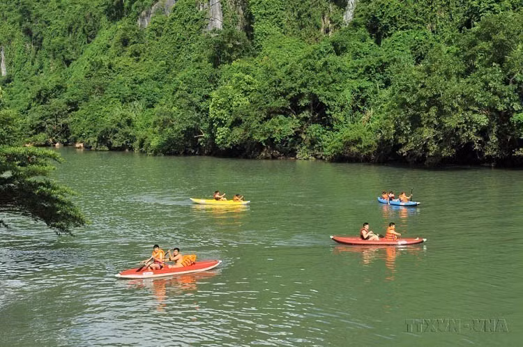 Tourists paddle boats to enjoy the scenery along the Chay River at Phong Nha – Ke Bang National Park. (Photo: VNA)