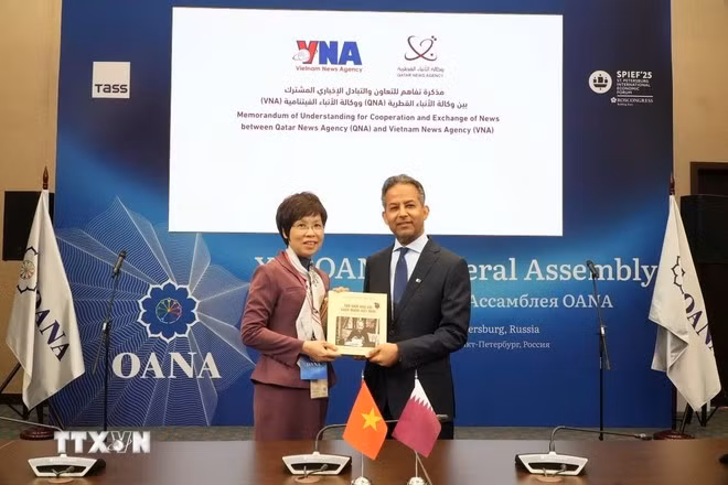 VNA Director General Vu Viet Trang introduces the photo book “100 Years of Vietnam’s Revolutionary Press” to international friends. (Photo: VNA)