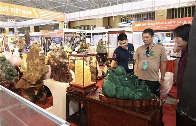 Visitors at exhibition booths on the opening day. (Photo: VNA)