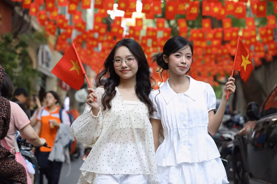 Au Trieu street with fluttering national flags attracts many young people who come to take photos, joining in the festive atmosphere of the April 30 celebration. (Photo: VNA)