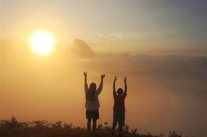 Watching the sunrise at Dong Cao Plateau. (Photo: VNA)