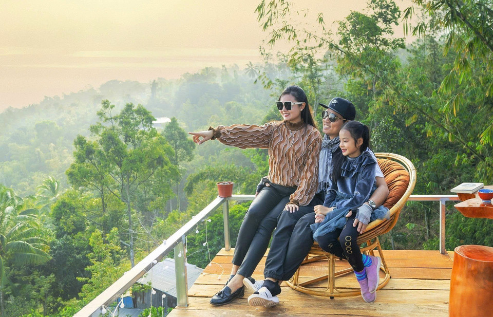 A tourist family enjoying tea together while watching the sunrise atop Cam Mountain. (Photo: VNA)