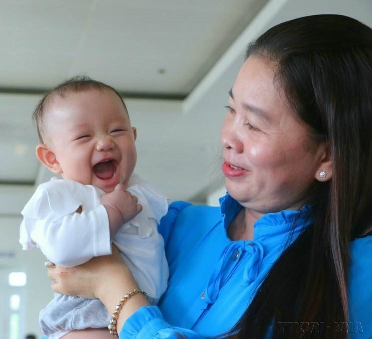 A girl accompanies her mother to receive an award honoring exemplary families with two daughters, held in Hau Giang province (now Can Tho city) (January 5, 2023). (Photo: VNA)