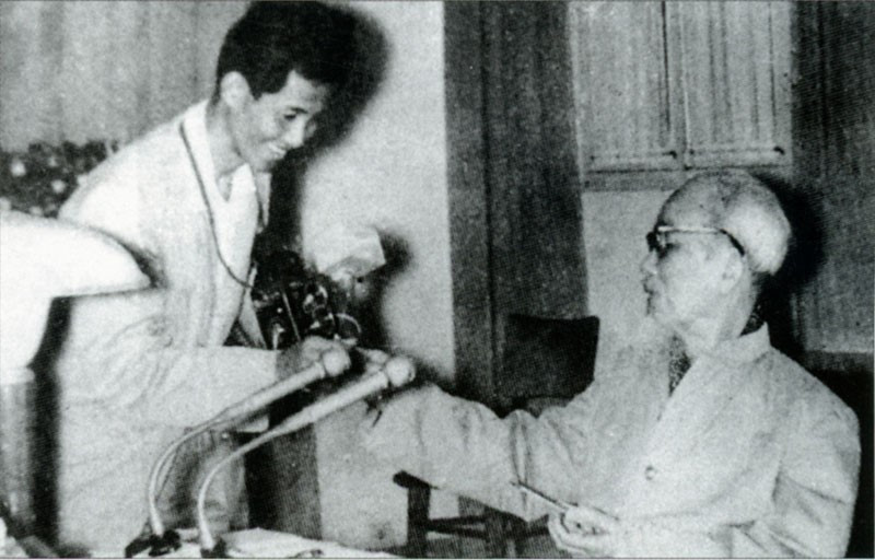 President Ho Chi Minh giving cigarette to journalist Lam Hong Long – the author of the famous photo feauring Uncle Ho leading a group in singing the song “Solidarity.” (Fhoto: VNA archives)