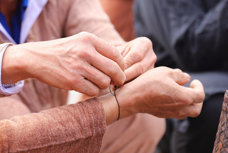 Once tied, the thread must be kept on the wrist until the next year’s New Year Thunder Festival. (Photo: VNA)