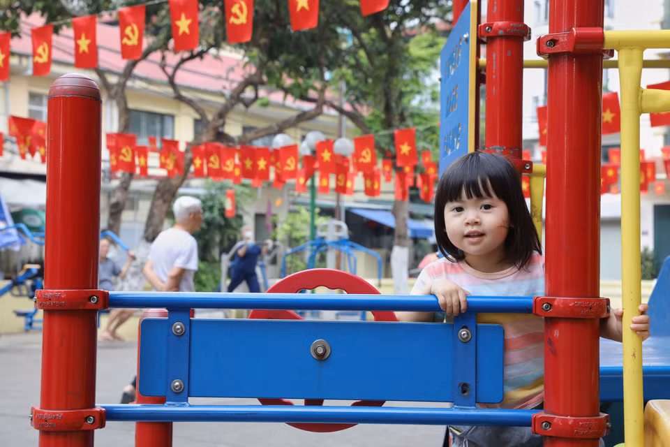 A child plays in an area where the national flag is proudly displayed. (Photo: VNA)