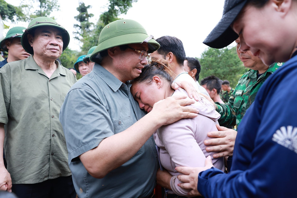 Prime Minister Pham Minh Chinh offers condolences to a family in Xa Dung commune who lost a loved one due to flooding. (Photo: VNA)