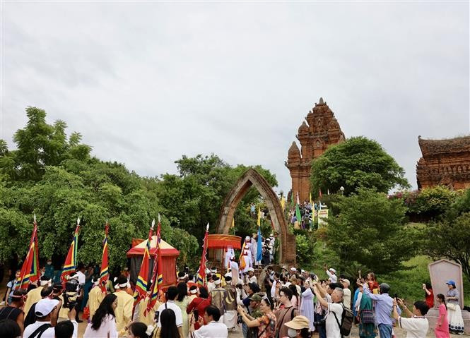 Crowds dressed in traditional attire solemnly enter the ancient tower, bringing offerings to honour their ancestors and deities. (Photo: VNA)