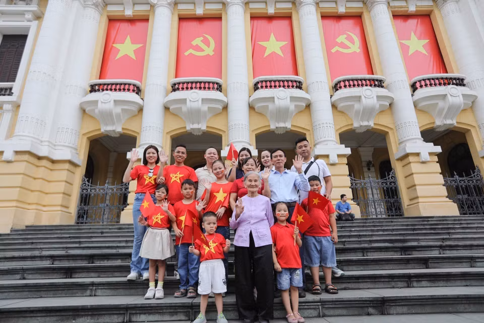 A large family poses for a photo in front of the Hanoi Opera House, capturing a special moment on the morning of April 30. (Photo: VNA)