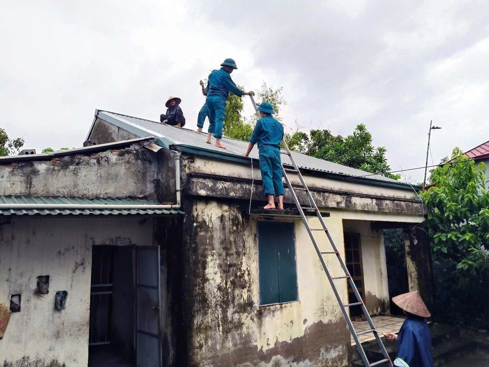 Militia forces assist local residents in reinforcing and securing houses in Phu Van ward, Ninh Binh province. (Photo: VNA)