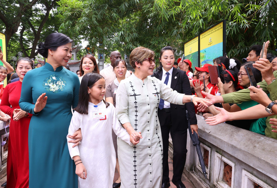 Local people enthusiastically welcome the two spouses, chanting “Vietnam – Cuba”. (Photo: VNA)