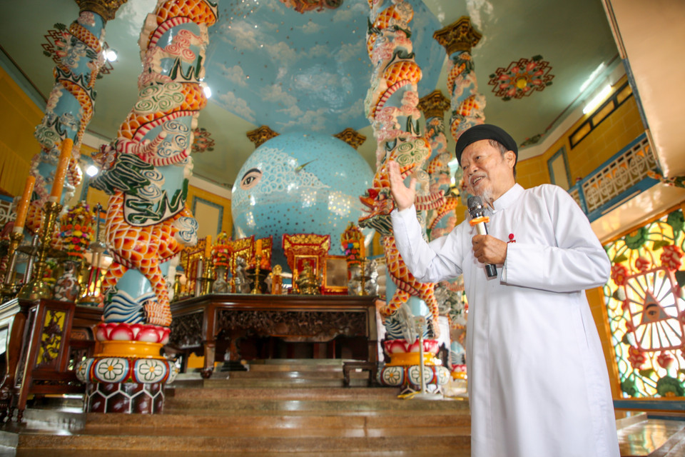 A representative of the Cao Dai Holy See introduces the temple’s history to visitors. (Photo: VNA)
