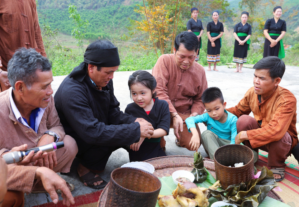 At the end of the ceremony, the shaman, village elders, and respected community members tie threads around the children's wrists, officially naming them and assigning them a family clan. (Photo: VNA)