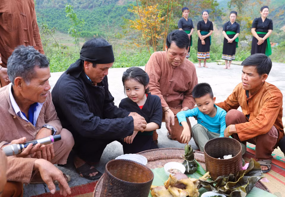 At the end of the ceremony, the shaman, village elders, and respected community members tie threads around the children's wrists, officially naming them and assigning them a family clan. (Photo: VNA)