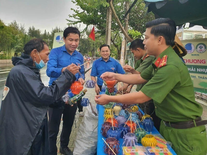 People exchange used plastic bottles, aluminum cans, and batteries for Mid-autumn festival lanterns as part of a green environmental protection program in Ben Tre province. (Photo: VNA)