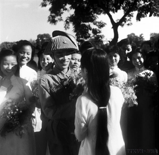 Major General Vuong Thua Vu, Commander of Division 308 and Chairman of the Military Administration Committee of Hanoi, is surrounded by students from Trung Vuong School offering flowers to congratulate him by Hoan Kiem Lake on the Liberation Day. (File photo: VNA)