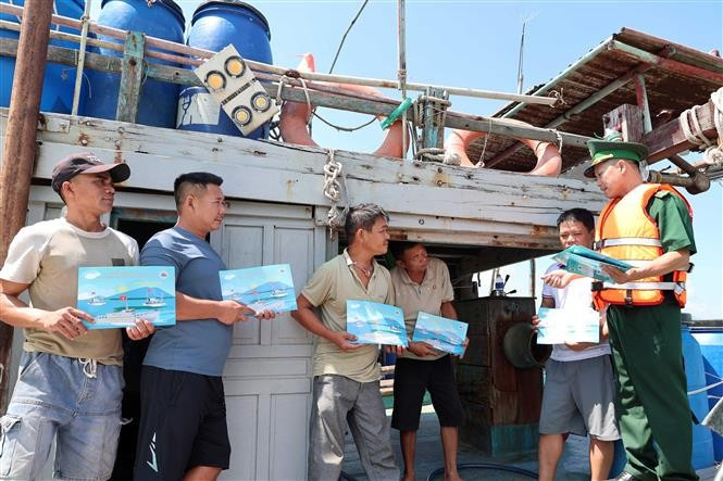 Officers and soldiers from Son Tra Border Guard Station (under Da Nang Border Guard Command) provide IUU information to fishermen from other provinces anchoring in the city’s waters to take shelter from storms. (Photo: VNA)