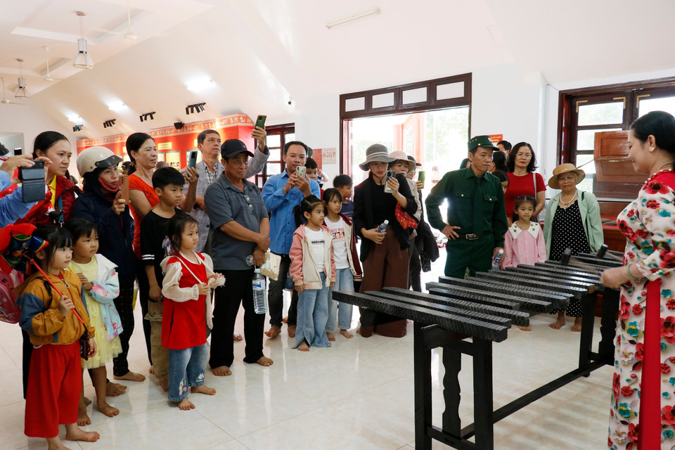 Tourists observe a stone xylophone (lithophone) performance at the Bom Bo hamlet exhibition house. (Photo: VNA)