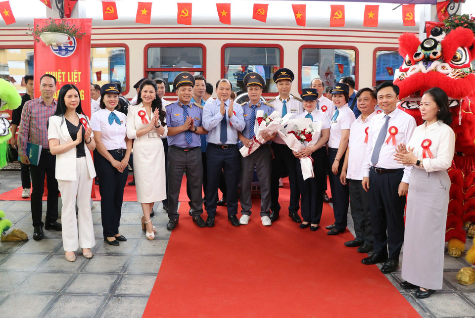 Deputy Minister of Culture, Sports and Tourism Le Hai Binh presents flowers to the crew of the “Flamboyant Flower” train. (Photo: VNA)