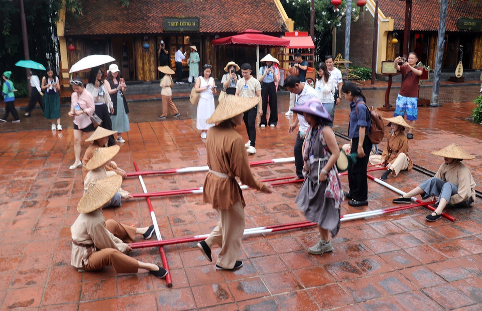 Tourists participate in a bamboo pole dance on Phu Quoc Pearl Island. (Photo: VNA)