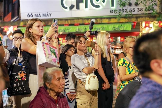 Foreign visitors also enjoy the traditional performances. (Photo: VNA)