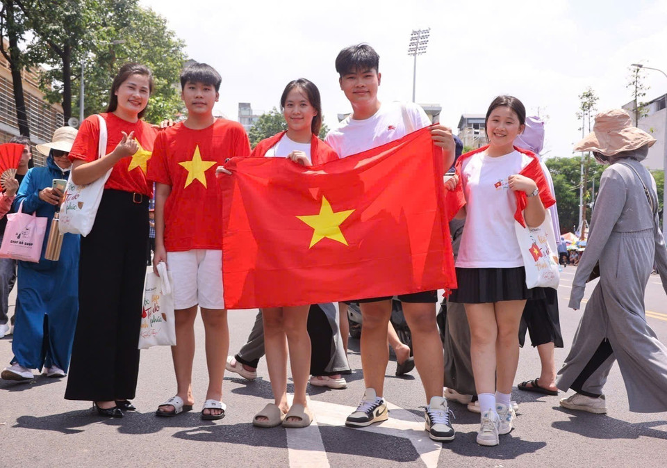 Young people carry national flags. (Photo: VNA)
