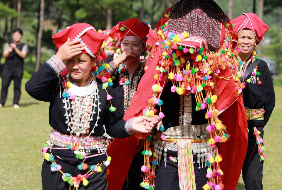 The bride must cover her head with a red cloth throughout the journey to the groom’s house. (Photo: VNA)