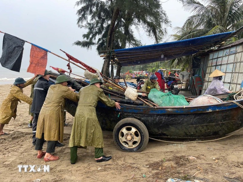 Residents and local authorities in Sam Sơn Ward, Thanh Hoa province, move boats ashore to shelter from the storm. (Photo: VNA)