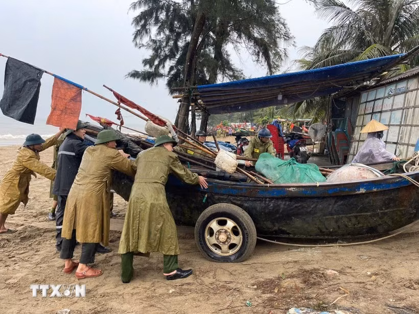 Residents and local authorities in Sam Sơn Ward, Thanh Hoa province, move boats ashore to shelter from the storm. (Photo: VNA)