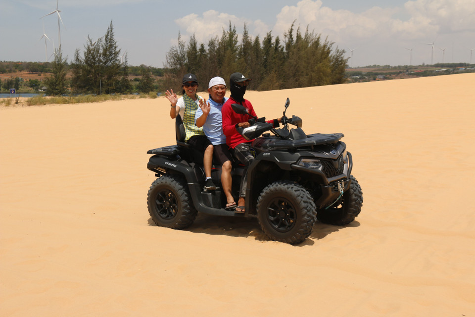 Visitors enjoy the experience of exploring the sand dunes by all-terrain vehicle. (Photo: VNA)