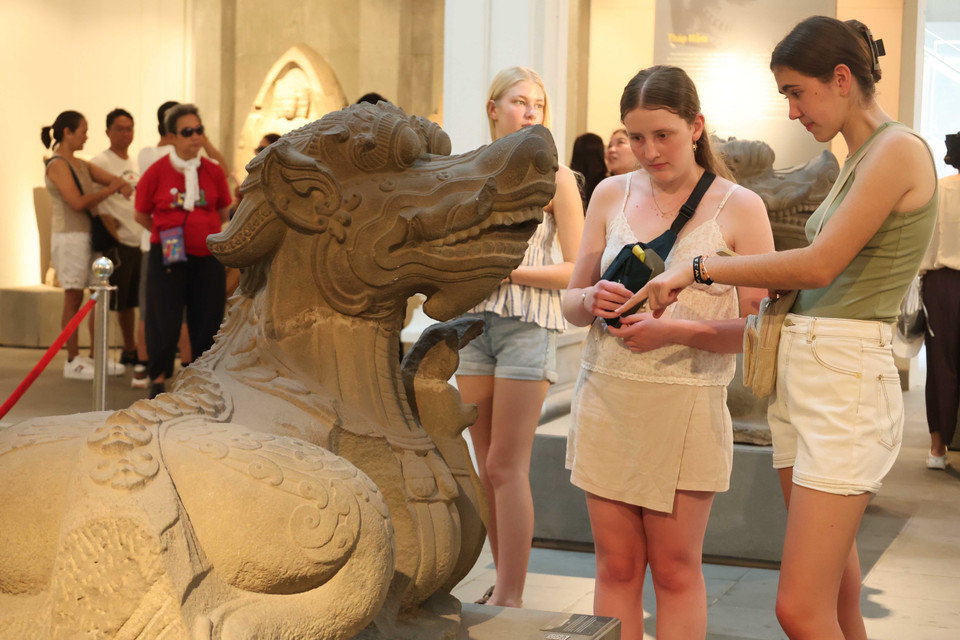 Foreign visitors explore the sculpture of Makara water creature - a distinctive feature of Cham art. (Photo: VNA)