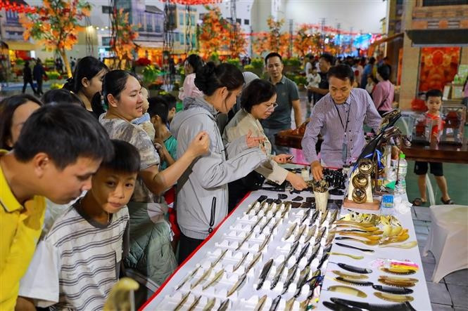 Traditional handicraft booths in the “Essence of Hanoi Autumn” space draw large crowds of visitors. (Photo: VNA)