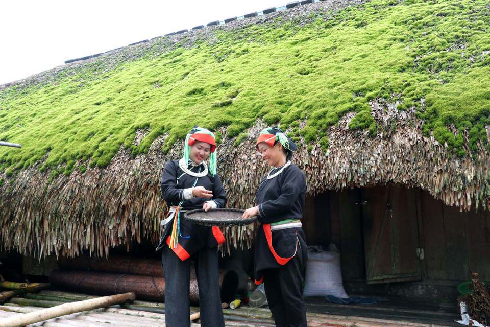 Dao women beside their moss-roofed home. (Photo: VNA)