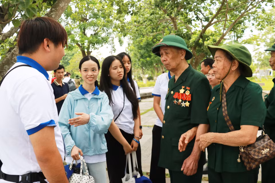 Members of the youth and student delegation meet with war veterans and former youth volunteers. (Photo: VNA)