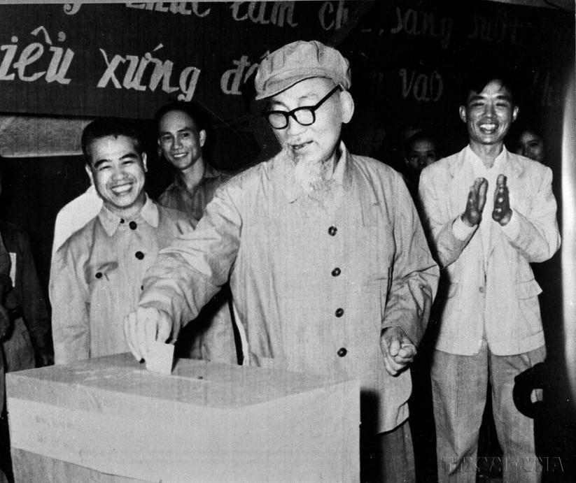 VNA reporter Dinh Chuong (standing behind President Ho Chi Minh) coveres the event of the President casting his vote in the People’s Council elections at all levels (April 1969). (Photo: VNA)