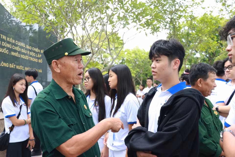 War veterans and former youth volunteers talk with members of the youth and student delegation. (Photo: VNA)