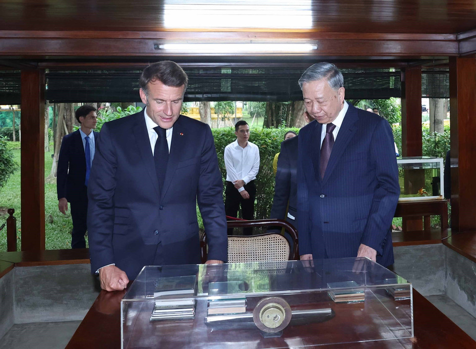 Party General Secretary To Lam and French President Emmanuel Macron visit President Ho Chi Minh's stilt house within the Ho Chi Minh Memorial Site. (Photo: VNA)