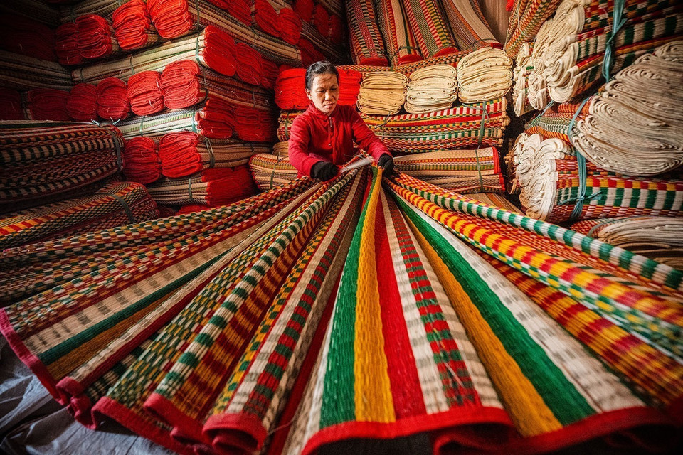 Inspecting the finished mats before selling. (Photo: VNA)