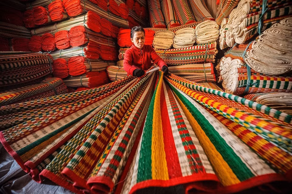 Inspecting the finished mats before selling. (Photo: VNA)