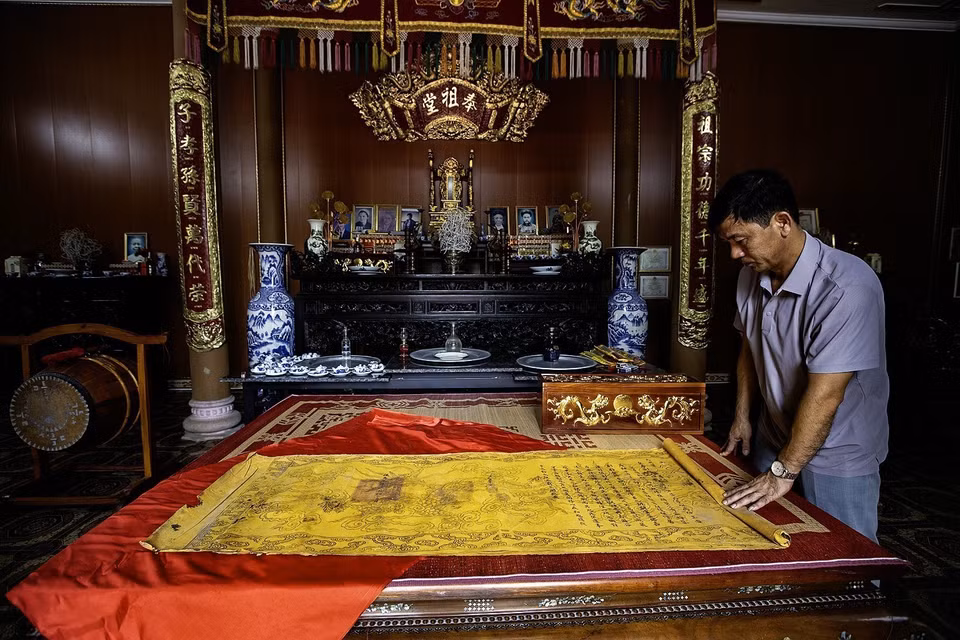 Dinh Cong Thao, fourth-generation descendant of Dinh Cong Thinh - who served as Governor of Hoa Binh from 1919 to 1928 under the Nguyen dynasty, pictured with royal decrees granted to the Dinh Cong family. (Photo: VNA)