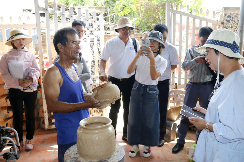 An artisan demonstrates traditional Cham pottery making for visitors. (Photo: VNA)