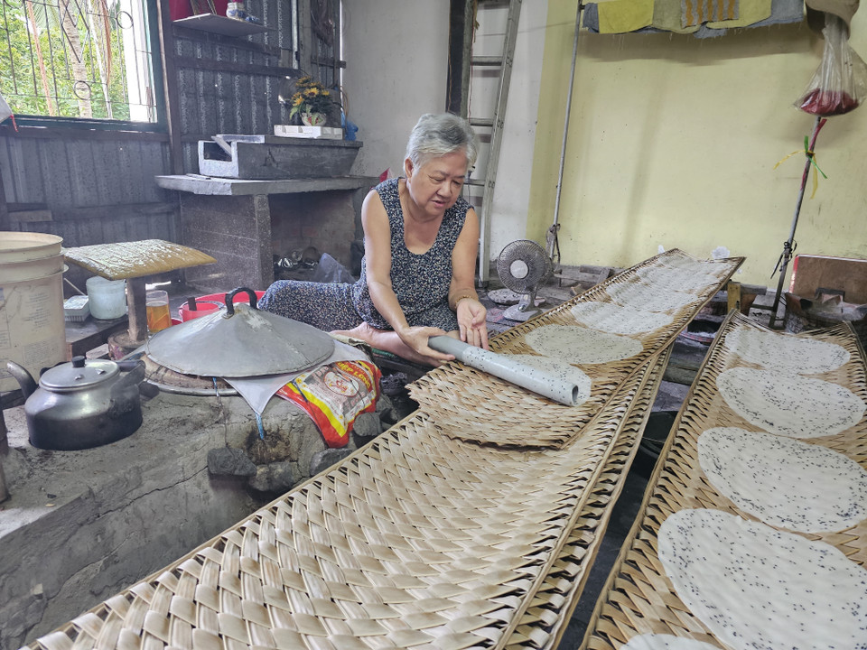 An elderly woman in Nghia Huan hamlet, My Thanh commune, Giong Trom district follows the previous generations to "keep the fire" of My Long rice paper craft. (Photo: VNA)