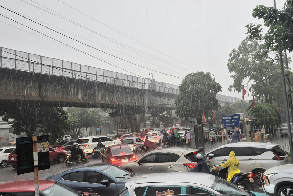 Heavy rain flooding several spots on Tan Xuan street, causing localised traffic congestion. (Photo: VNA)