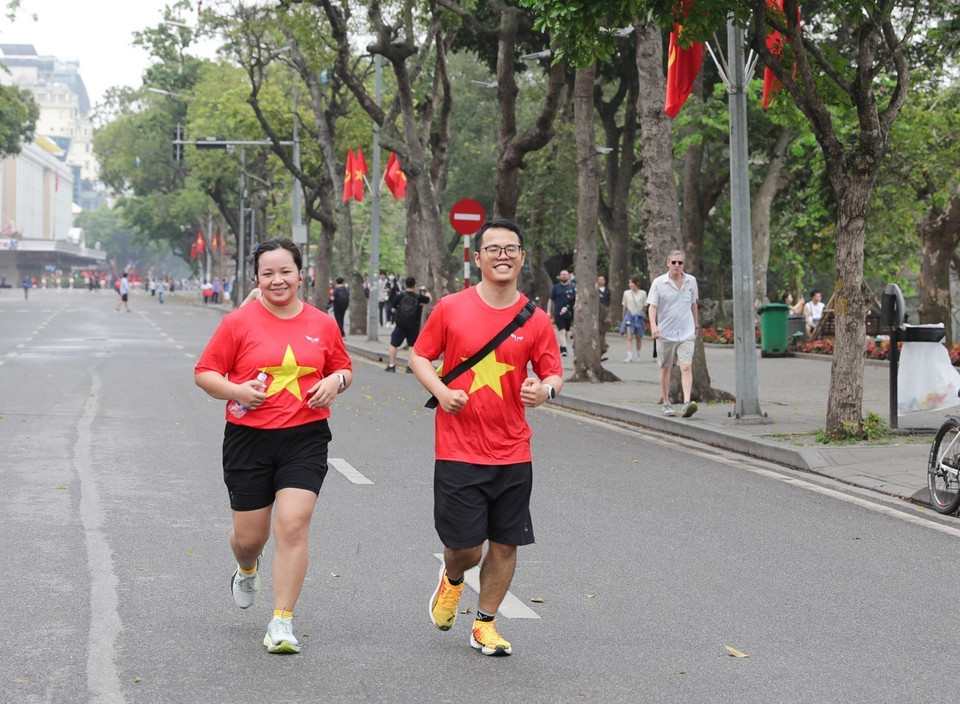 Many people, dressed in outfits featuring the national flag, proudly celebrate 50 years of the liberation of the south and national reunification. (Photo: VNA)