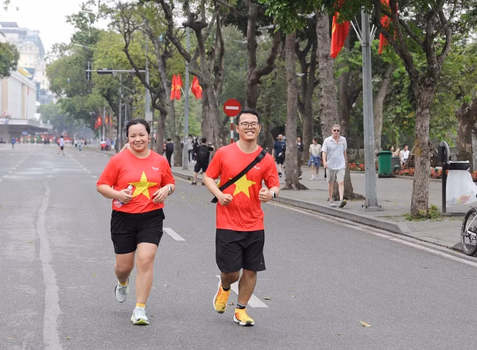 Many people, dressed in outfits featuring the national flag, proudly celebrate 50 years of the liberation of the south and national reunification. (Photo: VNA)