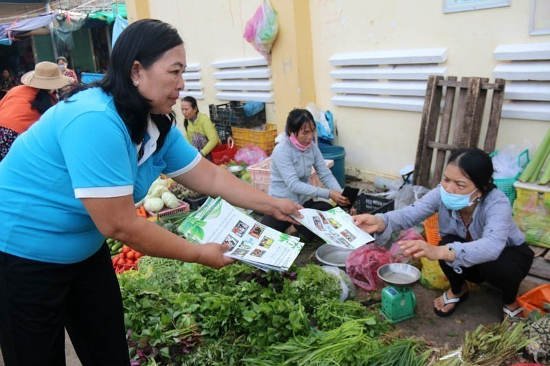 Leaflets are distributed to raise awareness about environmental protection and plastic waste reduction at Tam Thanh Market (Binh Thuan province). (Photo: VNA)