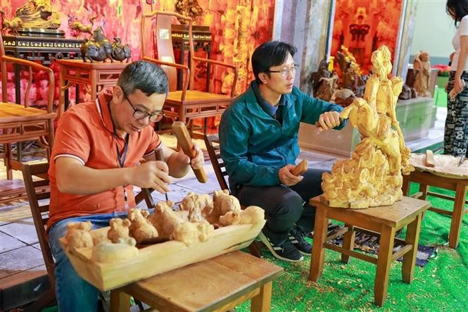 Artisans meticulously craft their products right in the “Essence of Hanoi Autumn” space. (Photo: VNA)