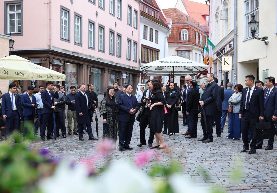 Prime Minister Pham Minh Chinh and his spouse are introduced about the history of Tallinn Old Town. (Photo: VNA)