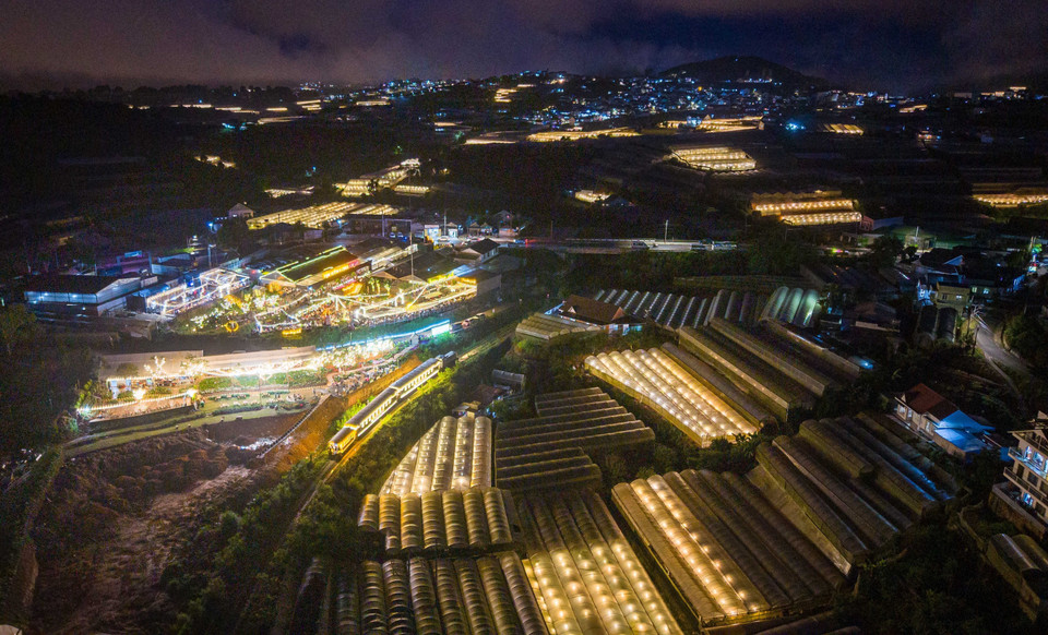 The train glides past brightly lit entertainment areas, vegetable gardens, and flower farms. (Photo: VNA)